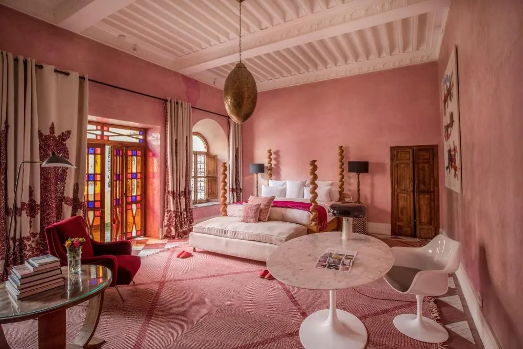 A white-arched riad courtyard with zellij tilework and a central fountain