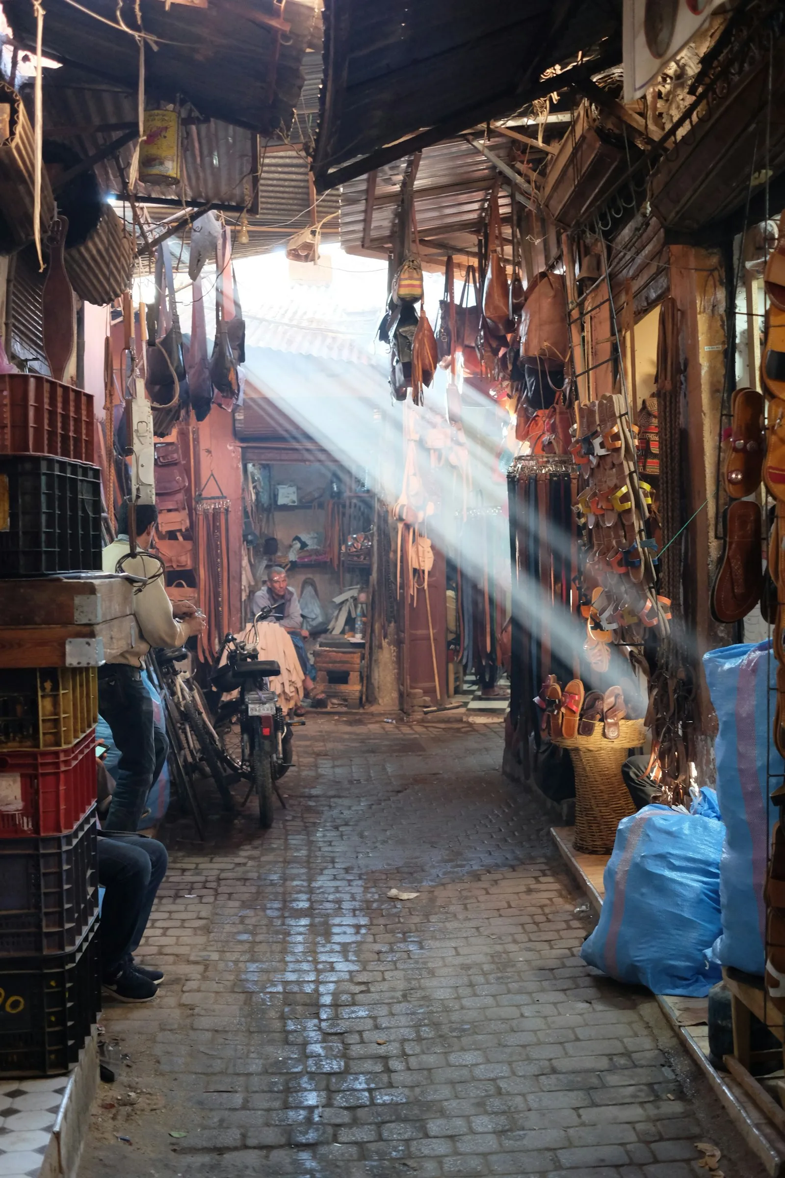 Sunbeams falling through the slatted roof of a covered souk in the Marrakech medina